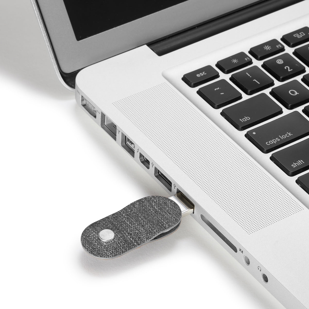 detached distil keymod usb inserted in macbook usb slot on a white backdrop